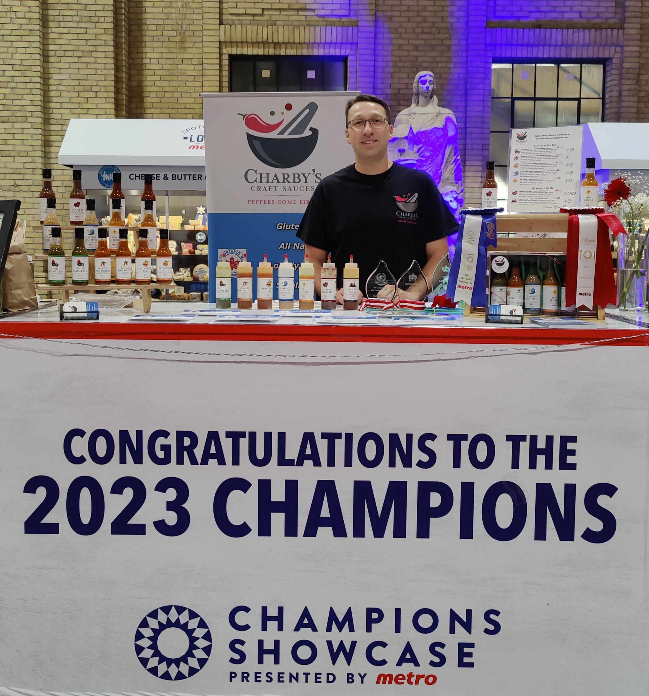 Paul at the Charby's Craft Sauces booth at the Royal Agricultural Winter Fair, surrounded by award ribbons